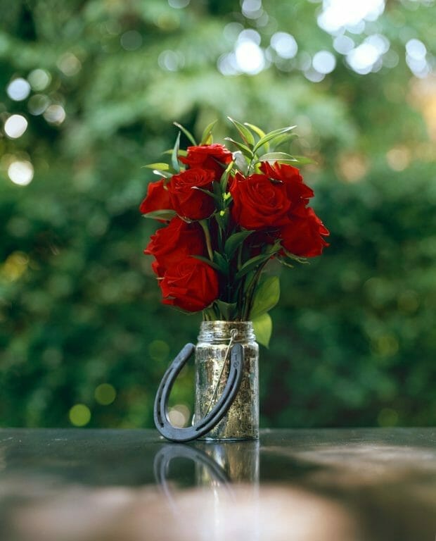 Vase of flowers on table with horseshoe